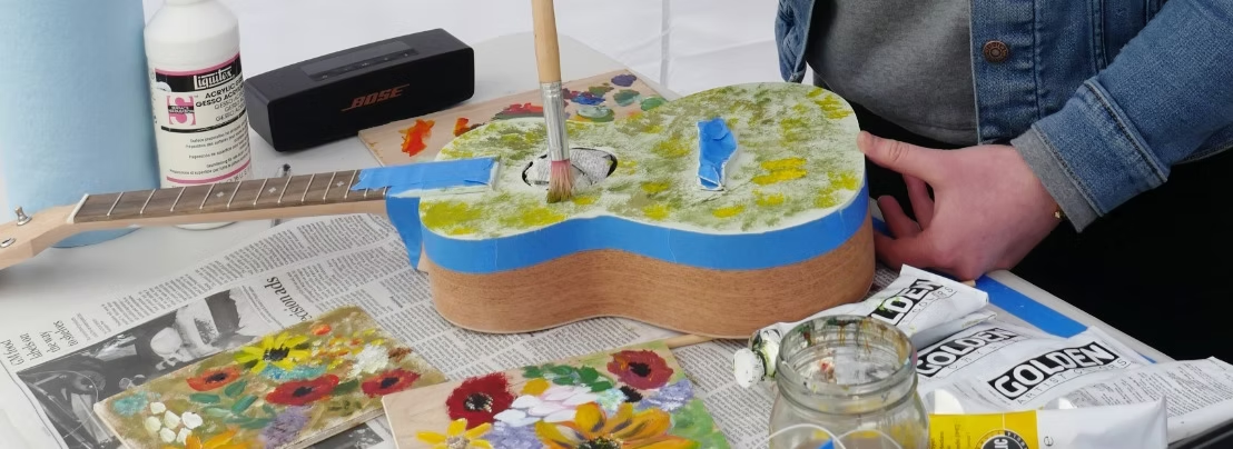 Hands painting a Butterfly Uke with acrylics